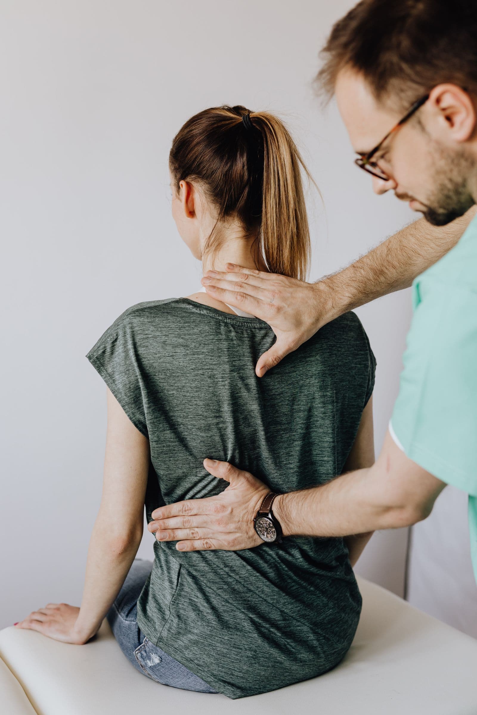 Terapeuta examina as costas de uma paciente
